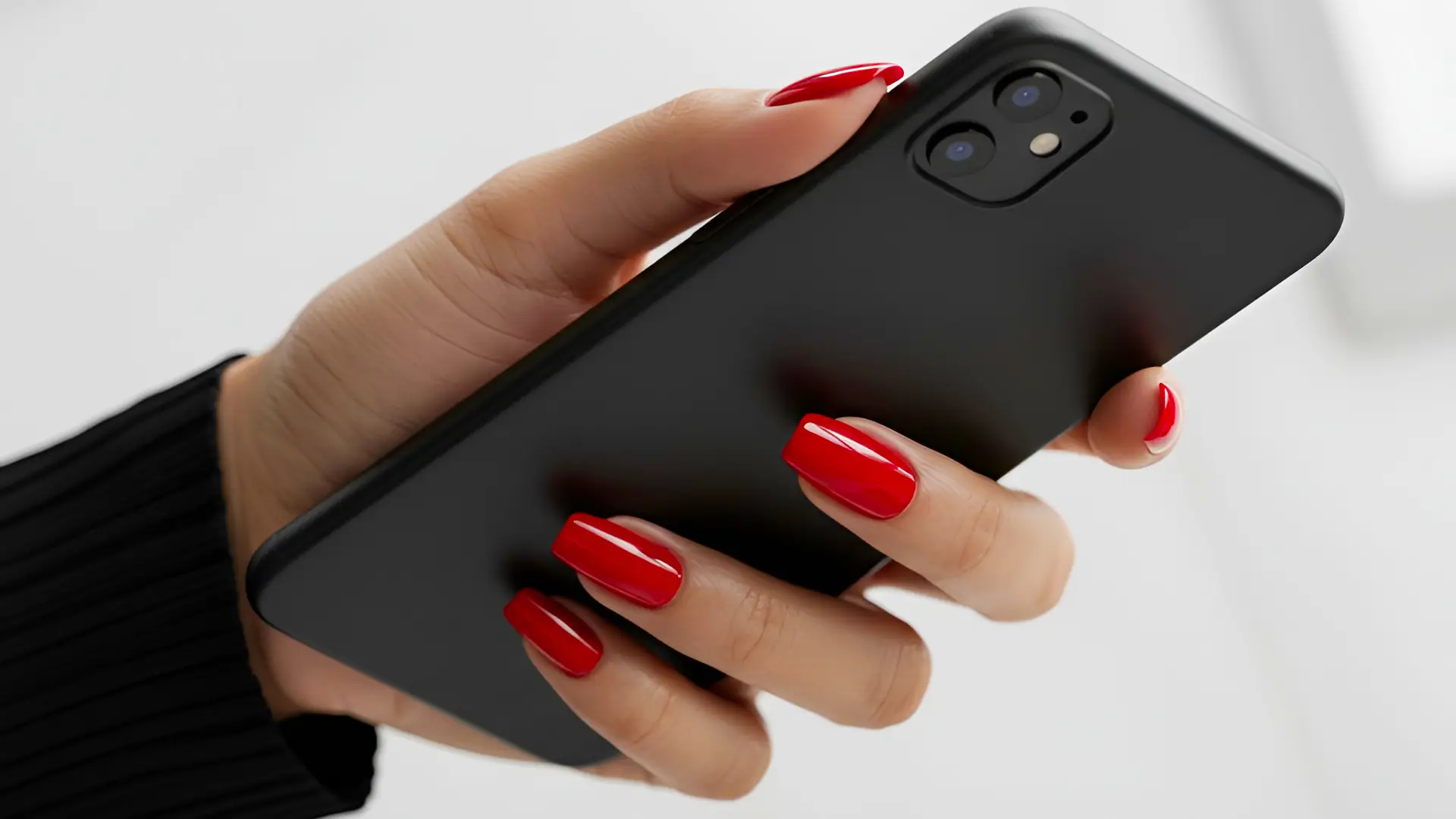 Glossy Red Squared Off Nails Holding a Phone